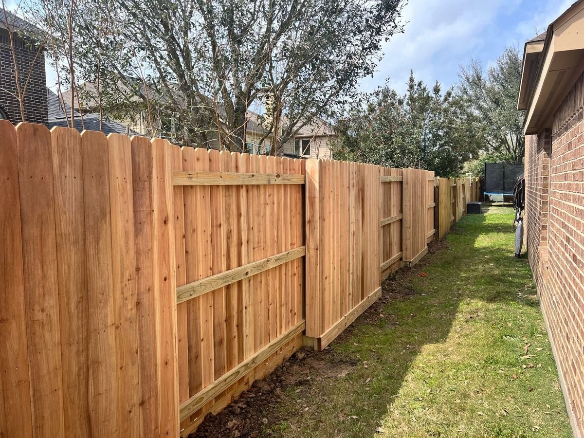 Wooden privacy fence lining a narrow side yard between houses in Brookshire TX