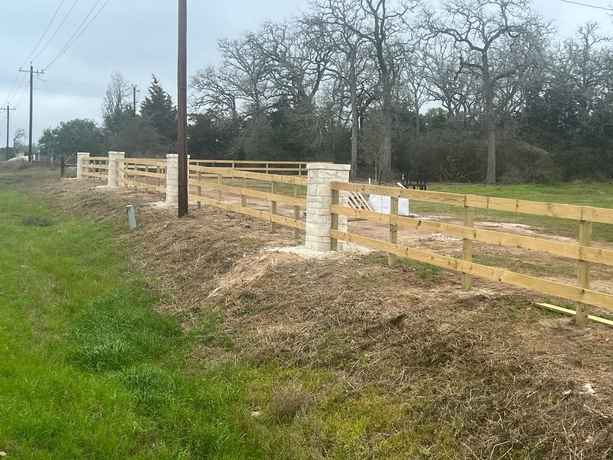 New wooden ranch fence along a grassy pasture installed by Pride of Texas Fence Company