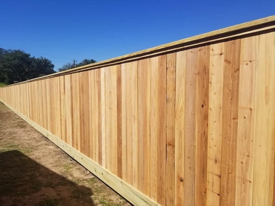 New tall wooden privacy fence with vertical boards installed by Pride of Texas Fence Company